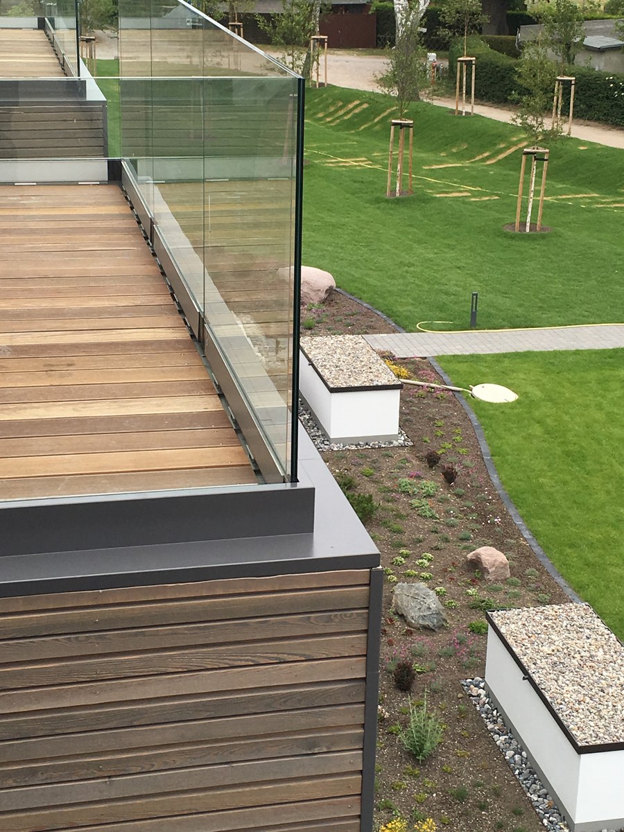 Ganzglasgeländer auf erhöhter Holzterrasse mit Gartenblick – Außenprojekt aus Wandlitz