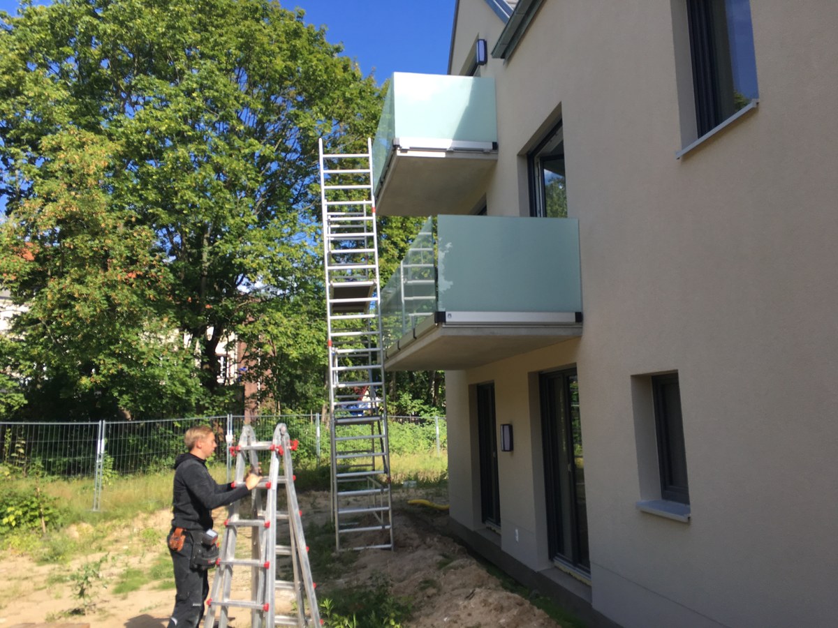 Montage satinierten Ganzglasgeländers an Glasbalkonen eines Neubaus – Glasermeister Wandlitz