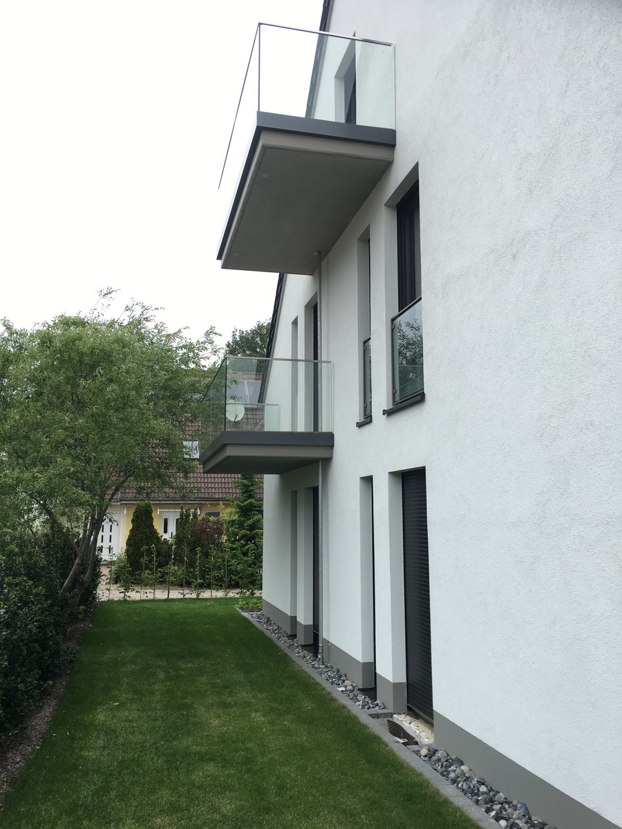 Weißes Wohnhaus mit Ganzglasgeländern an beiden Balkonebenen – realisiert in Wandlitz