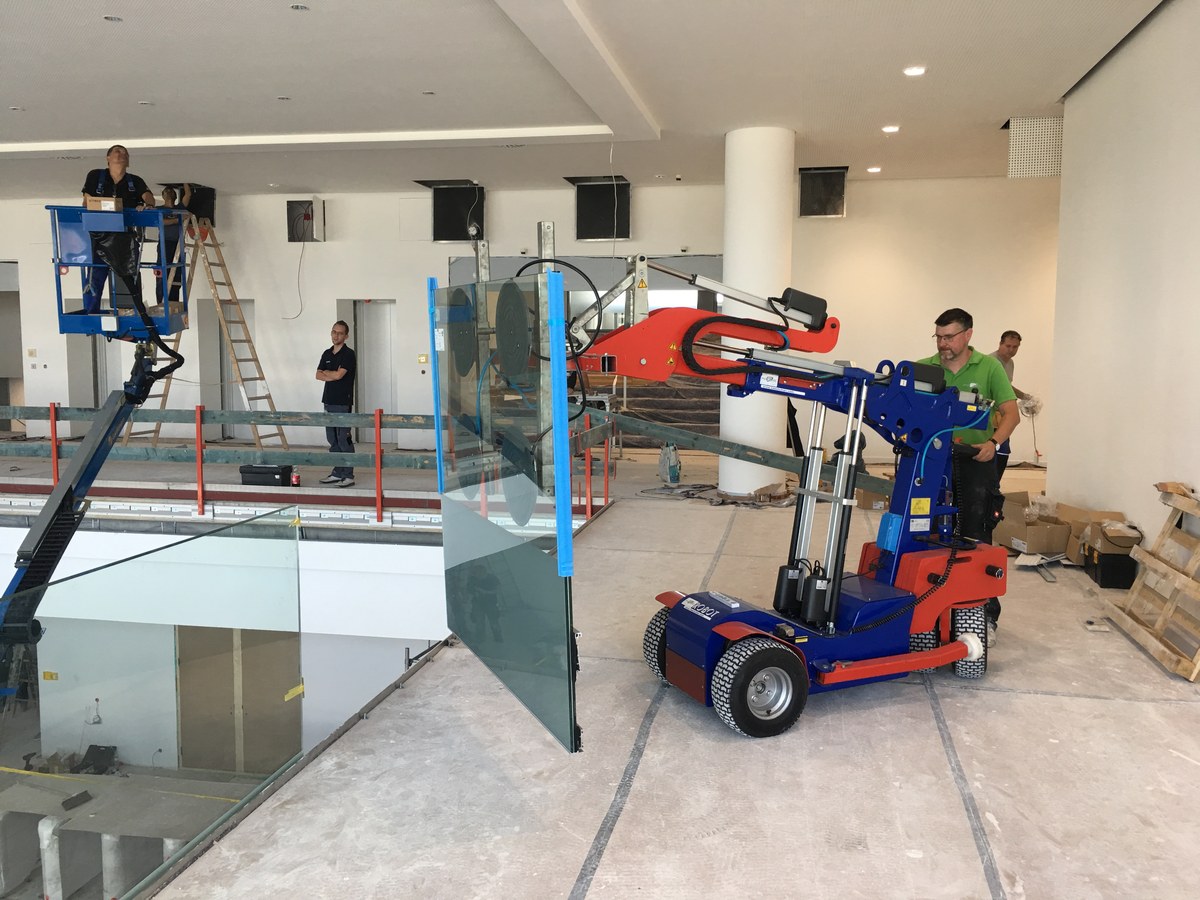 Montage großer Ganzglaswand mit Vakuumhebegerät auf Baustelle – professionelle Arbeit aus Wandlitz
